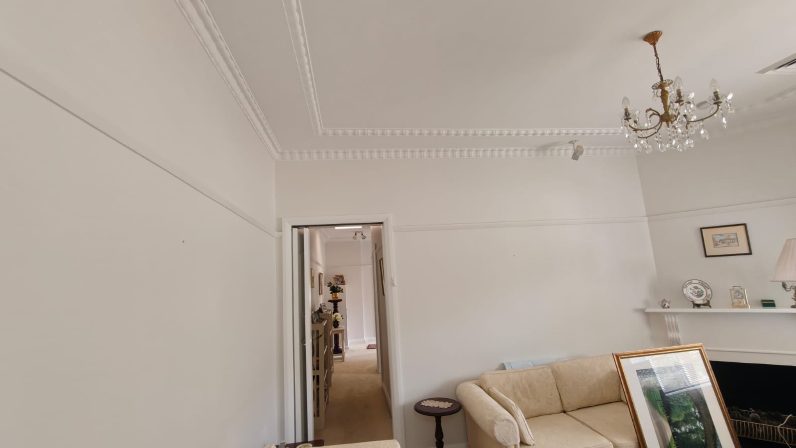Sunlit living room painted warm white